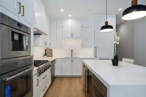 a kitchen with granite countertop a sink stainless steel appliances and cabinets