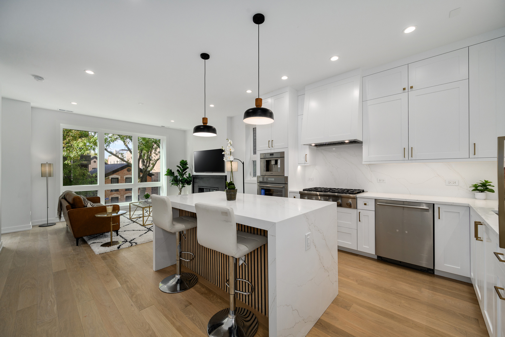 867 North Marshfield Avenue, Unit 2 Chicago, IL 60622 - Photo 7 of 19 a large kitchen with stainless steel appliances kitchen island granite countertop a stove a sink dishwasher and a dining table with garden view