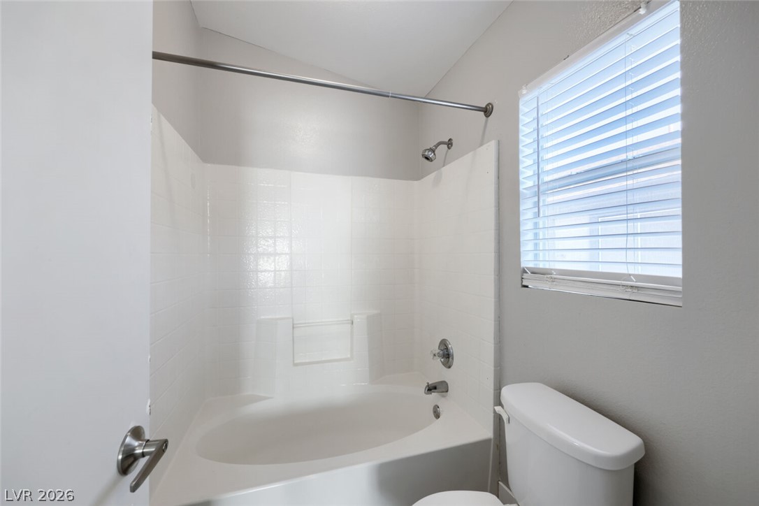 5985 High Steed Street, Unit 101 Henderson, NV 89011 - Photo 30 of 38 A well-lit primary bathroom features a combination shower and tub next to a conveniently placed window.
