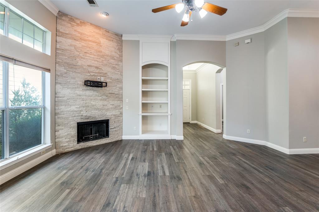 3230 Adirondack Lane Frisco, TX 75033 - Photo 6 of 27 an empty room with wooden floor a fireplace and windows