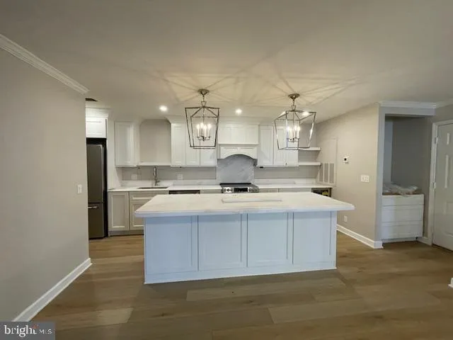 a view of an empty room with wooden floor fireplace and a window