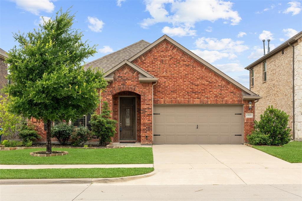 6909 Danridge Road Rowlett, TX 75089 - Photo 2 of 29 a view of a house with a yard and garage