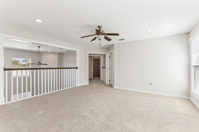 an empty room with a window and a fan
