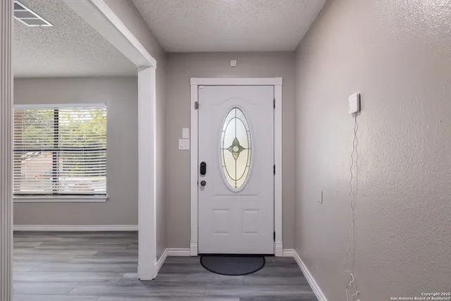 a view of empty room with wooden floor and window