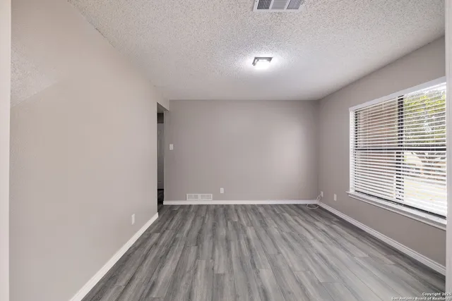a view of a room with wooden floor and window