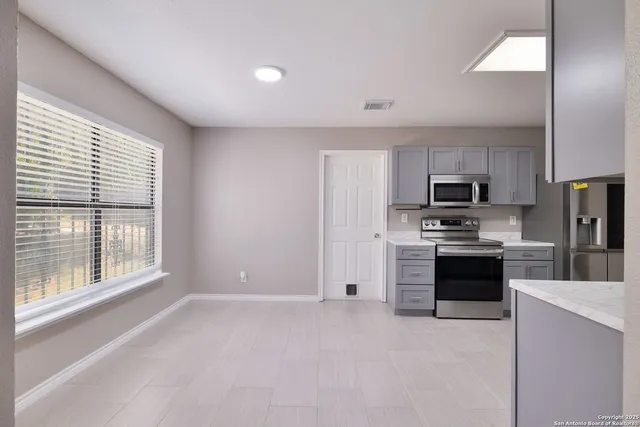 a kitchen with stainless steel appliances a refrigerator sink and microwave