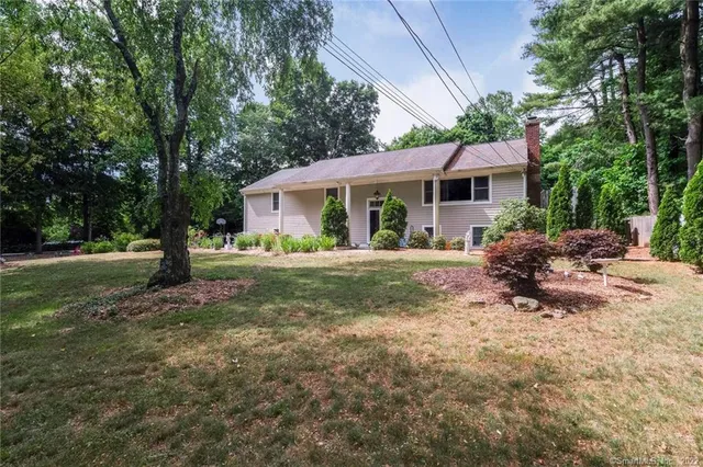 a view of a house with backyard and sitting area