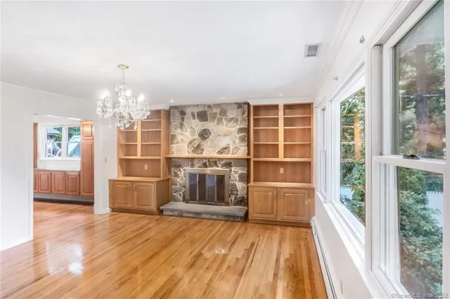 a view of empty room with wooden floor and windows