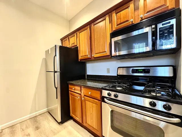 a kitchen with stainless steel appliances granite countertop a stove and a microwave