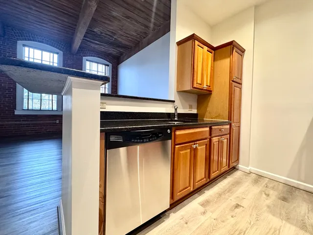 a view of a refrigerator in kitchen and a wooden floor