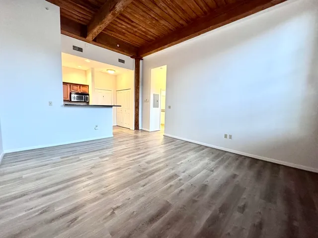a view of a room with wooden floor and a window