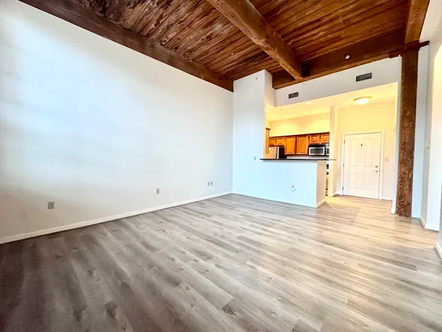 a view of empty room with wooden floor