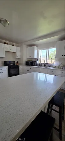 a kitchen with stainless steel appliances a table chairs in it and a window