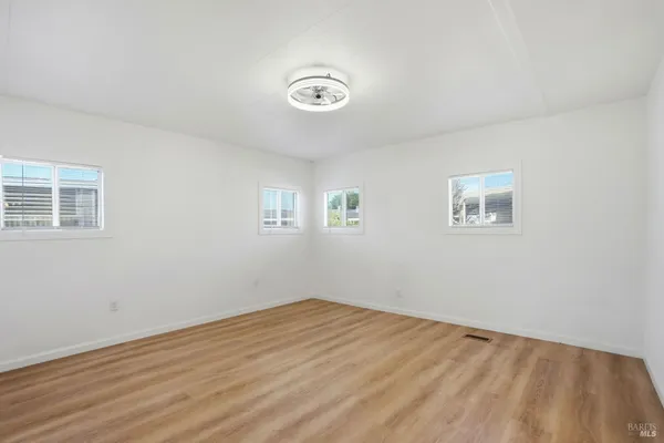 a view of empty room with wooden floor and window