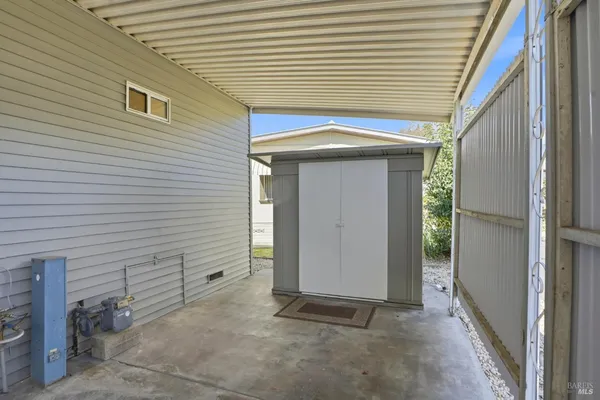 a view of a backyard with table and chairs with wooden fence and plants