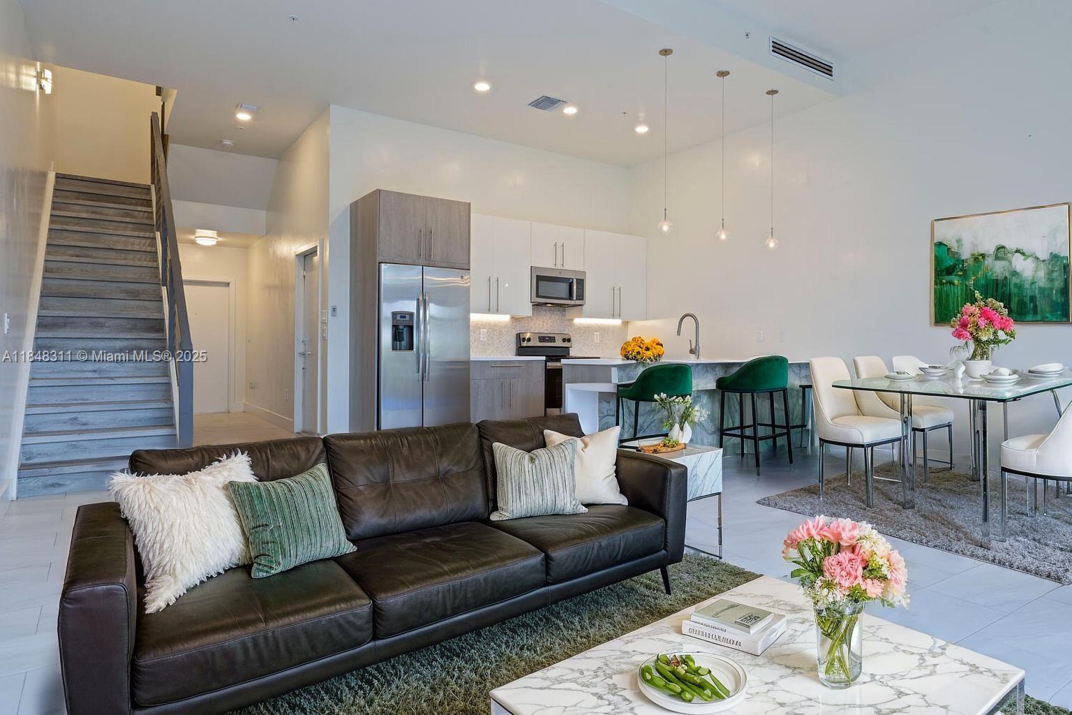 a living room with furniture kitchen and a potted plant