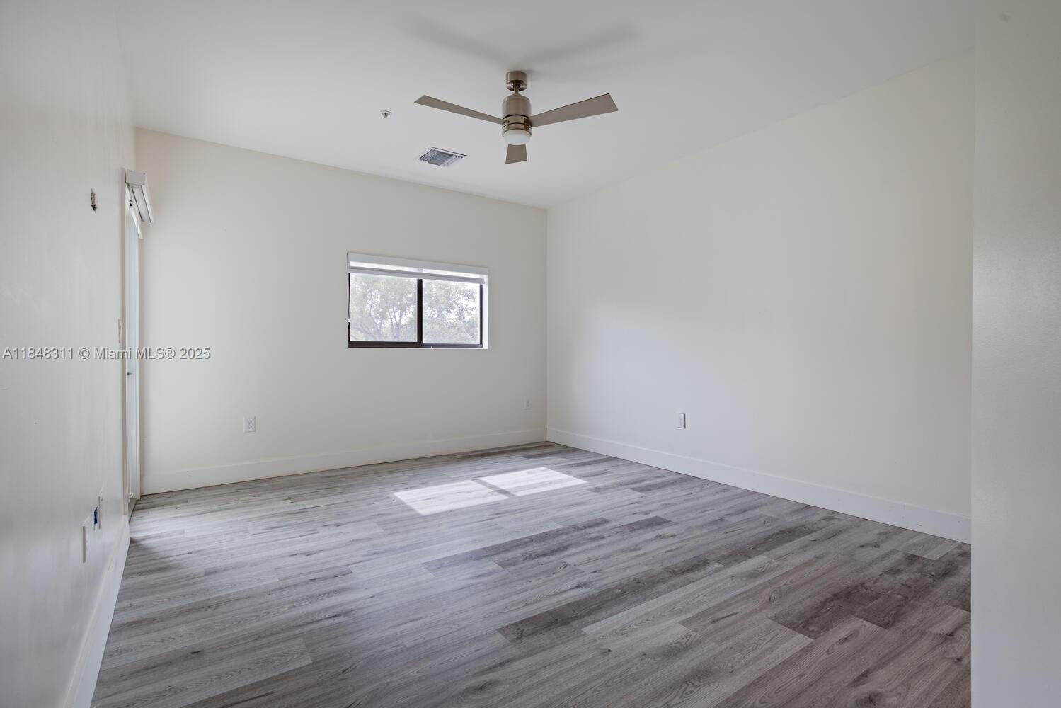 891 Northwest 45th Terrace Plantation, FL 33317 - Photo 12 of 33 an empty room with wooden floor and ceiling fan