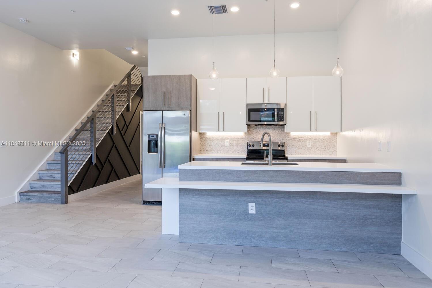 891 Northwest 45th Terrace Plantation, FL 33317 - Photo 4 of 33 a kitchen with stainless steel appliances granite countertop a sink a refrigerator and a stove