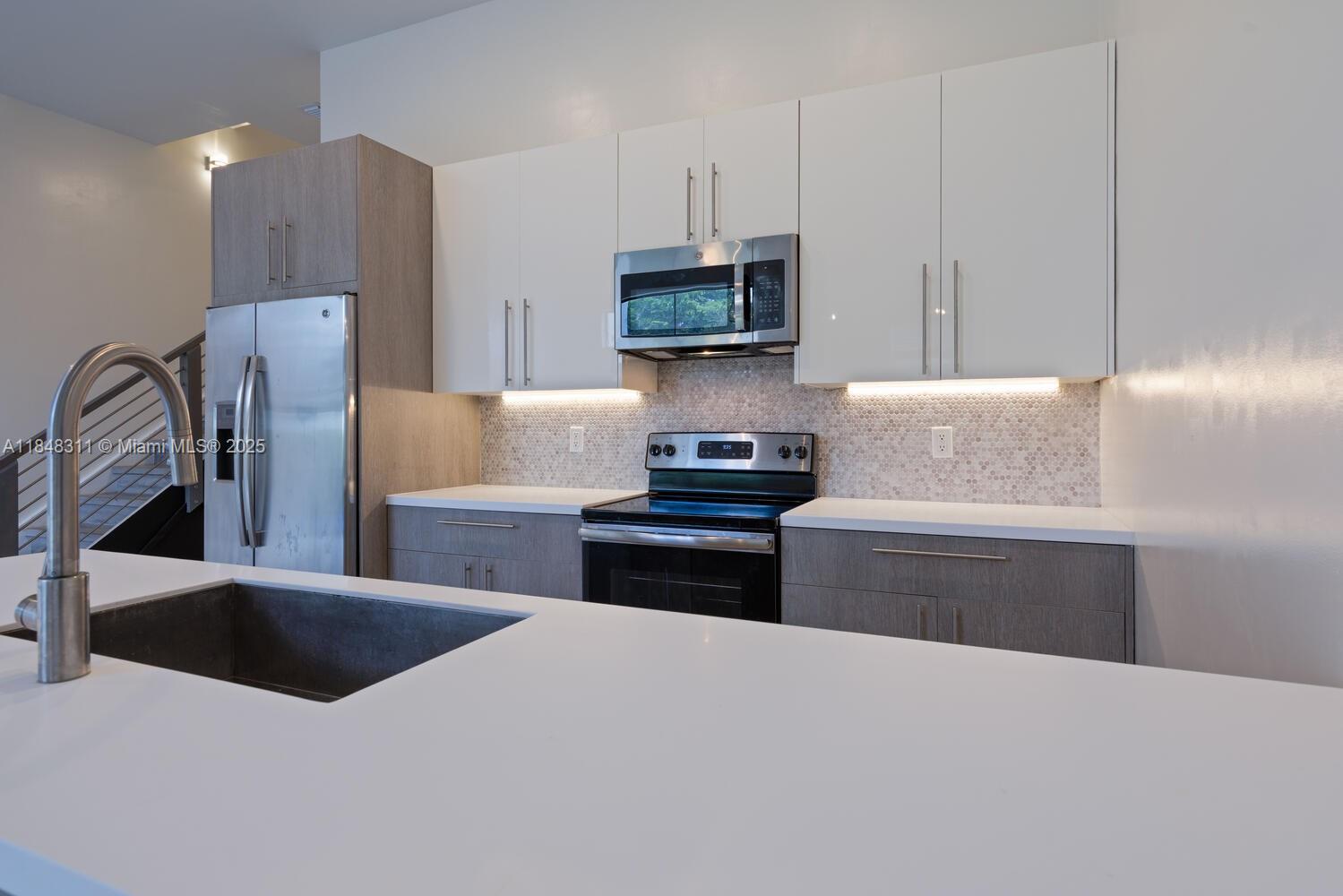 891 Northwest 45th Terrace Plantation, FL 33317 - Photo 6 of 33 a kitchen with stainless steel appliances a refrigerator a stove and a sink