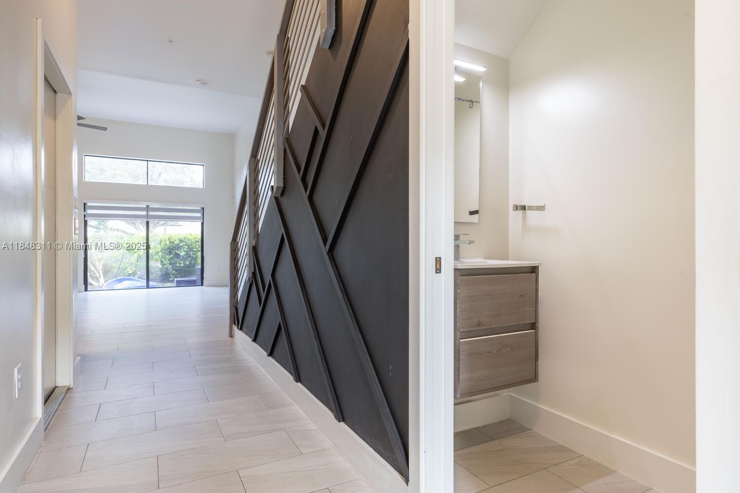 891 Northwest 45th Terrace Plantation, FL 33317 - Photo 9 of 33 a view of hallway with stairs and a floor to ceiling window