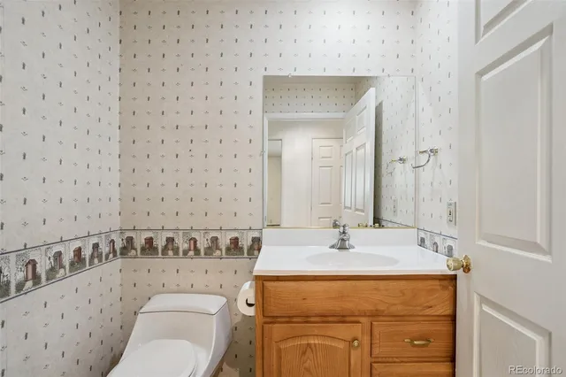a bathroom with a granite countertop sink a toilet mirror and vanity