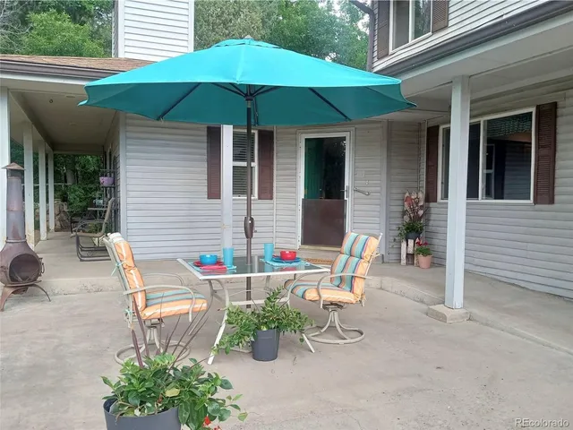 a patio with a table and chairs under an umbrella