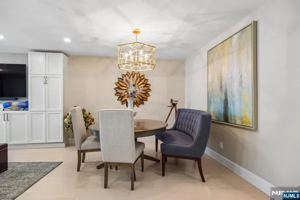 a view of a dining room with furniture a chandelier and wooden floor