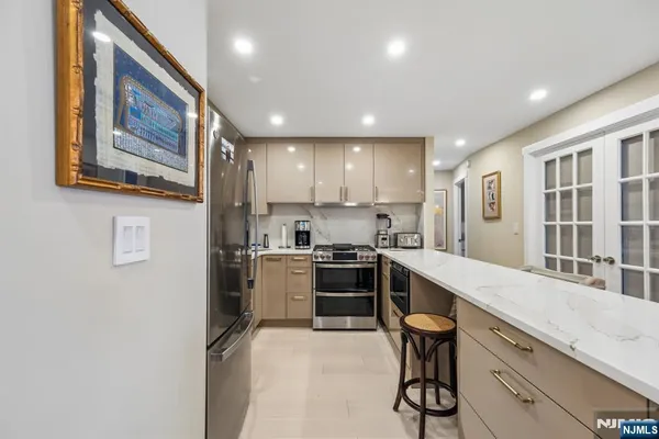 a kitchen with stainless steel appliances granite countertop a refrigerator and a stove top oven