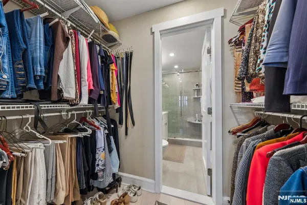 a view of walk in closet with clothes and shoes