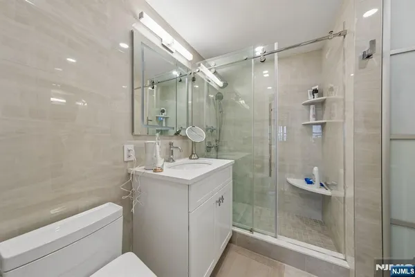 a bathroom with a shower sink vanity and mirror