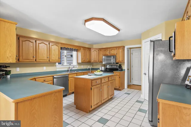 a kitchen with stainless steel appliances granite countertop a sink stove refrigerator and cabinets