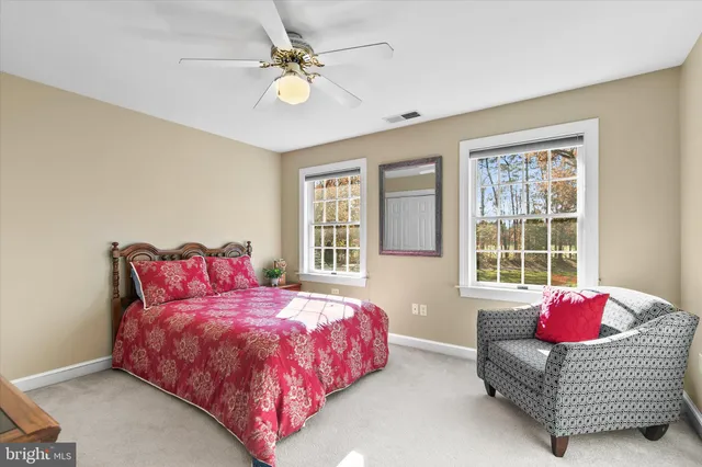 a bedroom with furniture and a ceiling fan