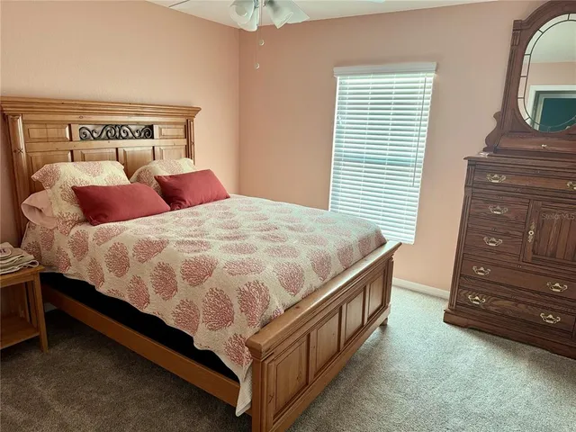 a bed sitting in a bedroom next to a window and dresser