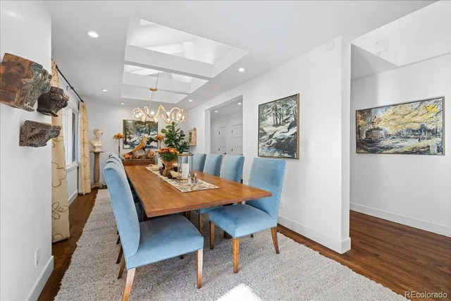 a view of a dining room with furniture a rug and wooden floor