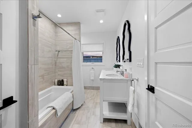 a bathroom with a sink a bathtub and a mirror