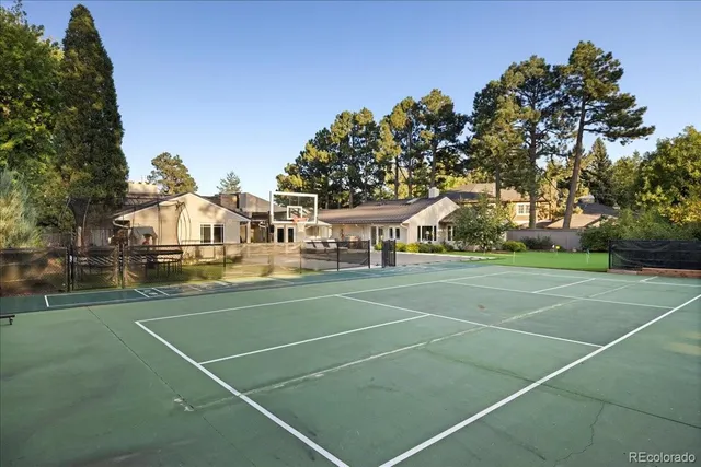 a view of a tennis ground with large trees