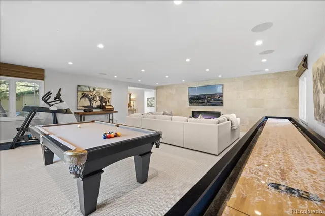 a living room with furniture pool table and a flat screen tv
