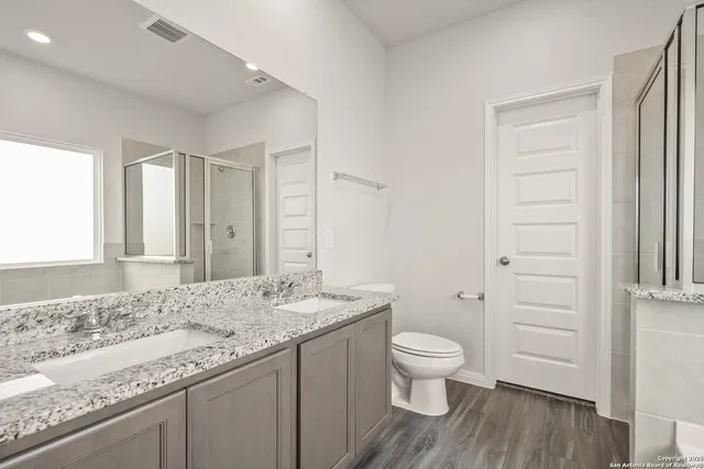 a bathroom with a granite countertop sink toilet and shower