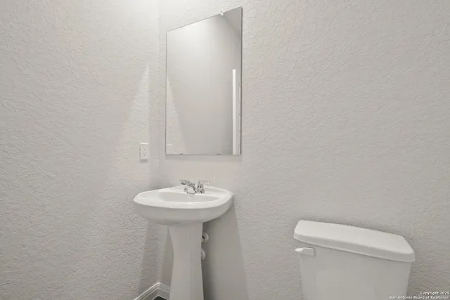 a bathroom with a sink a toilet and mirror