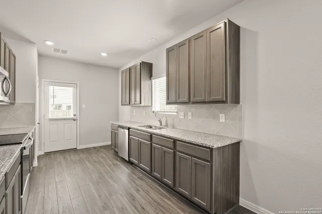 a kitchen with a sink stove and cabinets