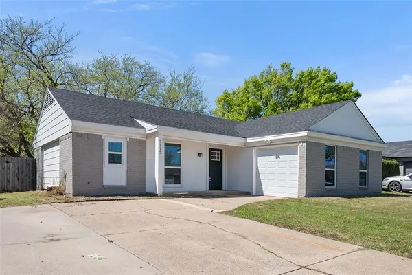 front view of a house with a yard and a garage