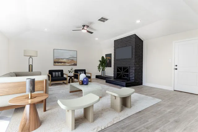 a living room with furniture a fireplace and a flat screen tv