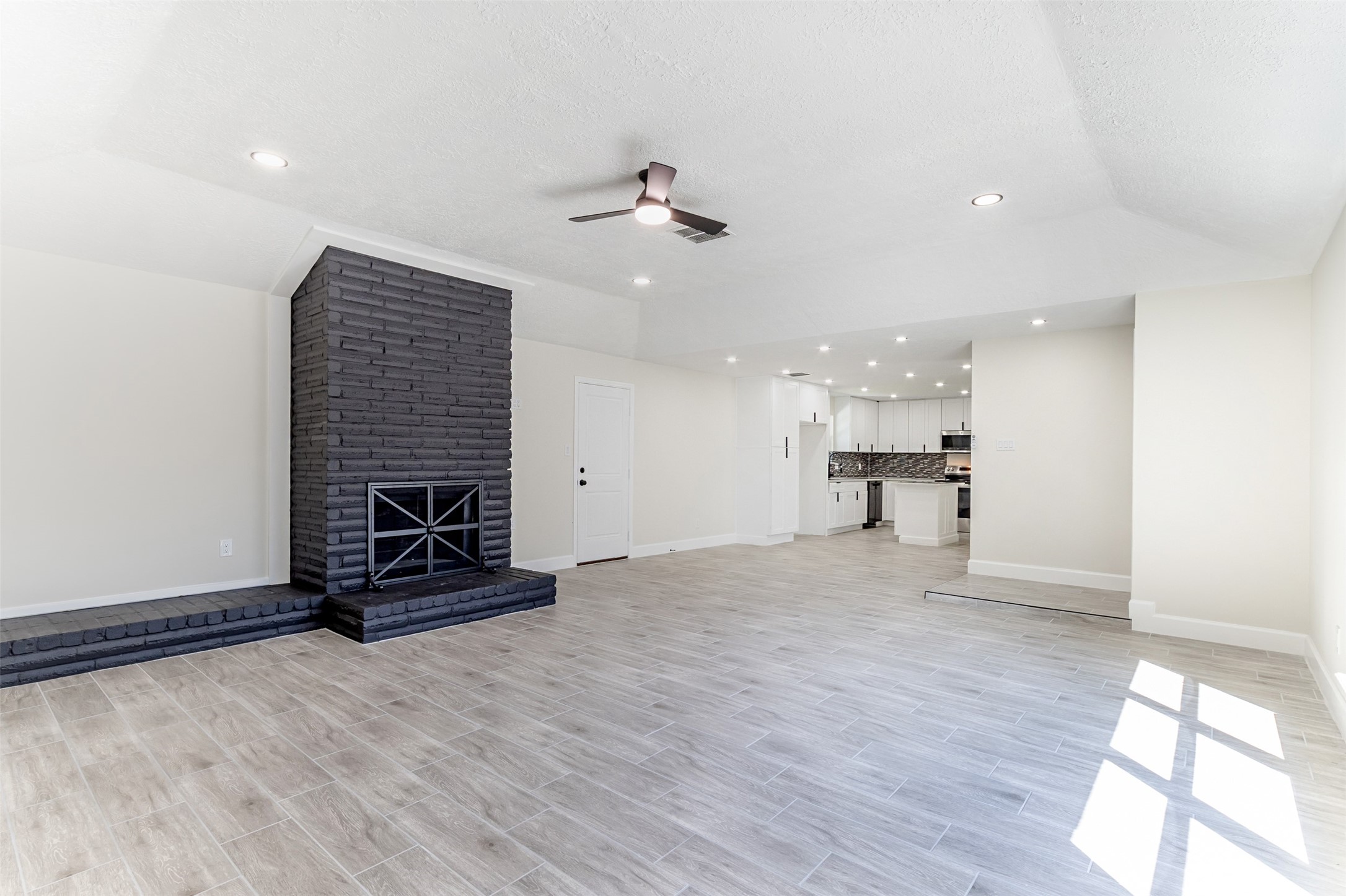 11203 Rousseau Drive Houston, TX 77065 - Photo 3 of 50 an empty room with wooden floor a ceiling fan and windows