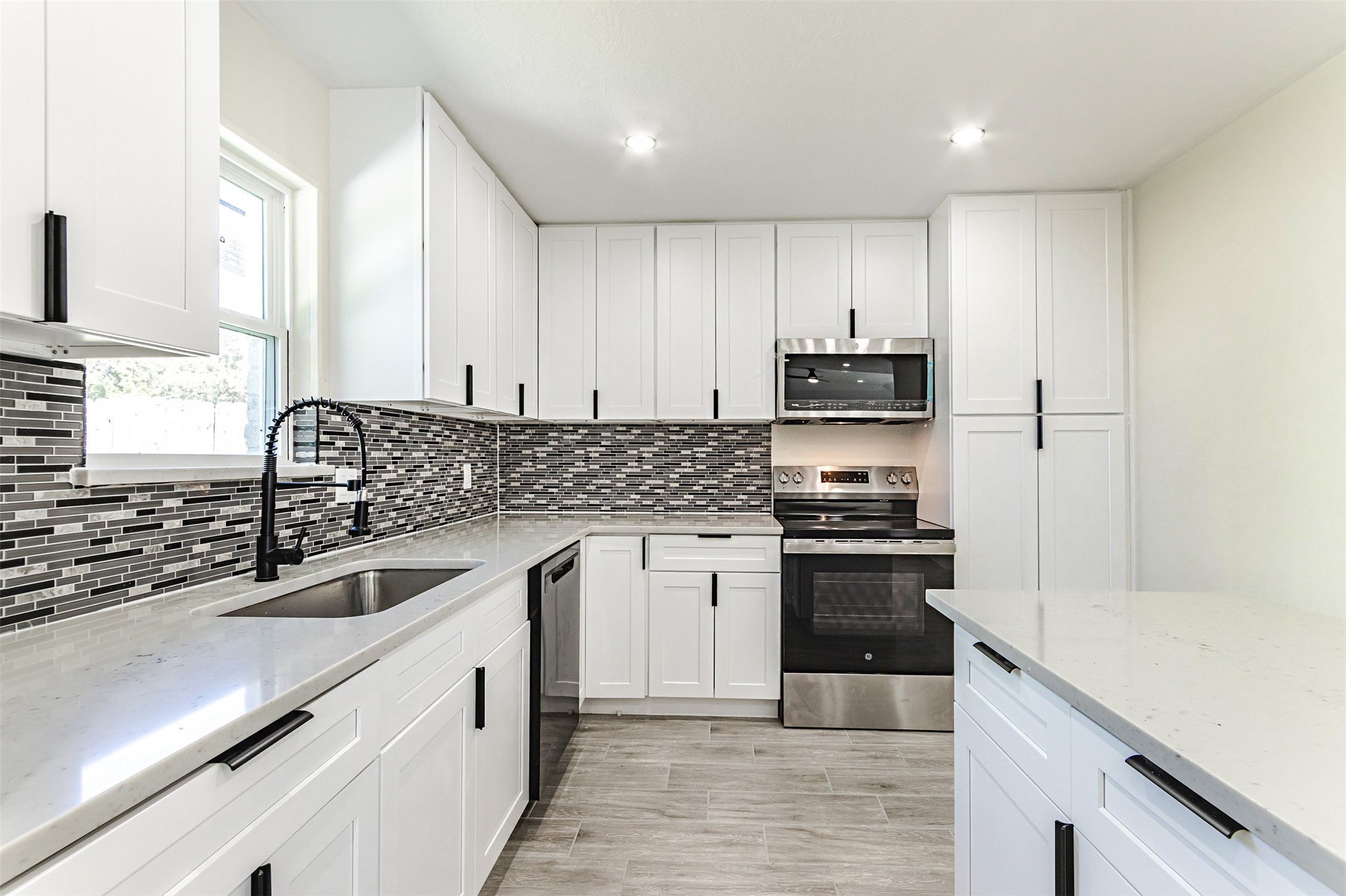 11203 Rousseau Drive Houston, TX 77065 - Photo 10 of 50 a kitchen with granite countertop white cabinets and stainless steel appliances