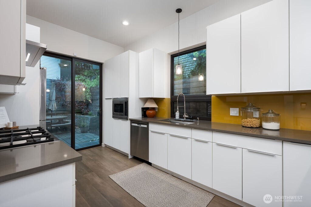 4815 Evanston Avenue North, Unit B Seattle, WA 98103 - Photo 15 of 37 a kitchen with stainless steel appliances granite countertop a stove a sink and a refrigerator
