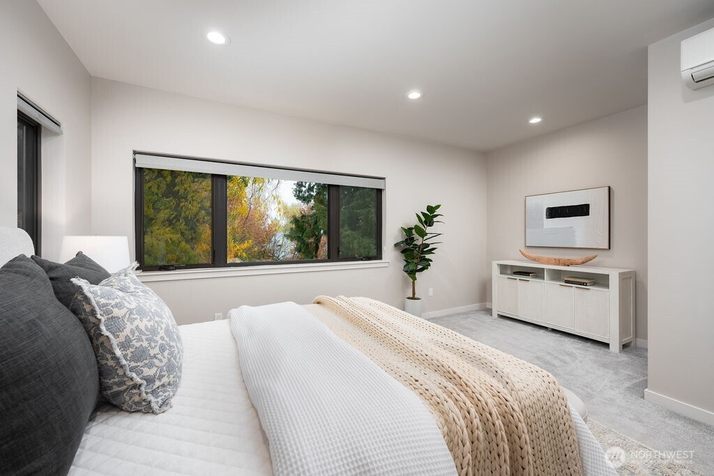 4815 Evanston Avenue North, Unit B Seattle, WA 98103 - Photo 17 of 37 a spacious bedroom with a large bed and a large window