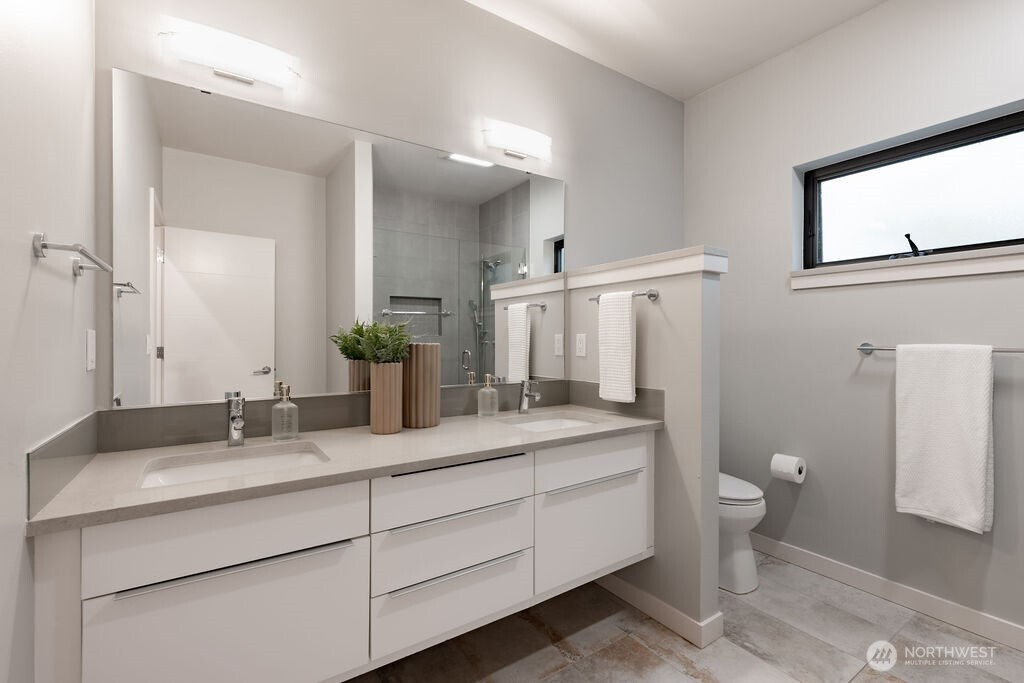 4815 Evanston Avenue North, Unit B Seattle, WA 98103 - Photo 19 of 37 a bathroom with a double vanity sink toilet and a mirror