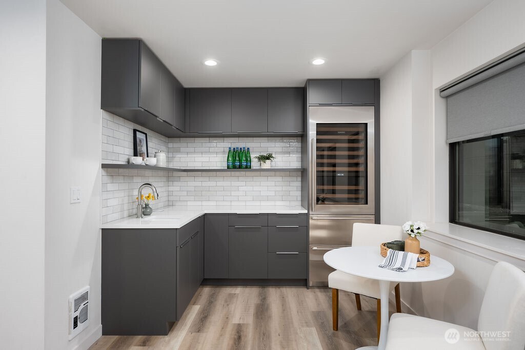 4815 Evanston Avenue North, Unit B Seattle, WA 98103 - Photo 28 of 37 a kitchen with stainless steel appliances a sink a kitchen island a stove a table and chairs