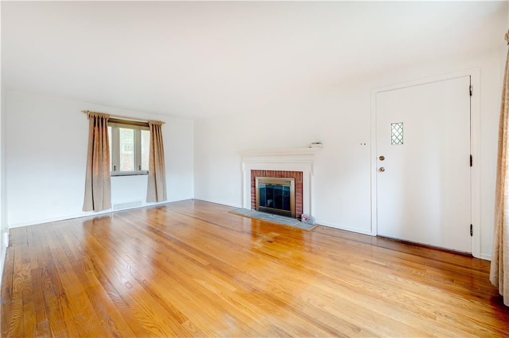 271 Newburn Drive Mt. Lebanon, PA 15216 - Photo 2 of 24 a view of an empty room with wooden floor fireplace and a window