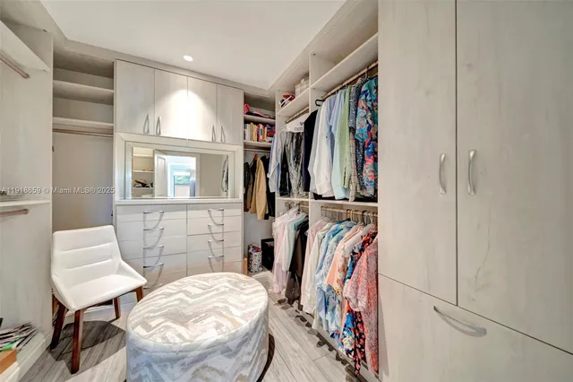 a view of walk in closet with clothes and shoes